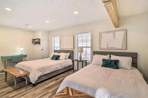 1 dormitorio con 2 camas y mesa en Chic Cottage Retreat with Grill, 2 Mi to MSU!, en Starkville