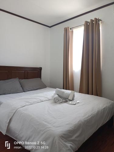 una camera da letto con un grande letto bianco e una finestra di Ethan's lodge a Mangangpico