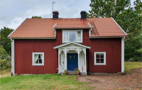a red house with a red roof and a blue door at Beautiful Home In Älmhult With Kitchen in Älmhult