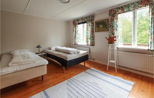 1 dormitorio con 2 camas y 2 ventanas en Beautiful Home In lmhult With Kitchen, en Älmhult