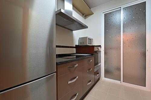 a kitchen with stainless steel appliances and a glass door at Alojamiento Alcantara in Alora