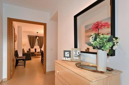 a living room with a vase of flowers on a dresser at Alojamiento Alcantara in Alora