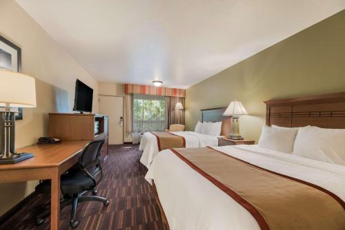 a hotel room with two beds and a desk at Best Western Town and Country Inn in Cedar City