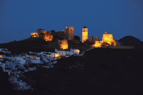 a castle on top of a hill at night at Alojamiento Alcantara in Alora