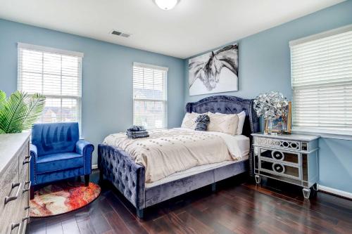1 dormitorio con paredes azules, 1 cama y 1 silla azul en Game Room and Gym Downtown DC Home!, en Washington