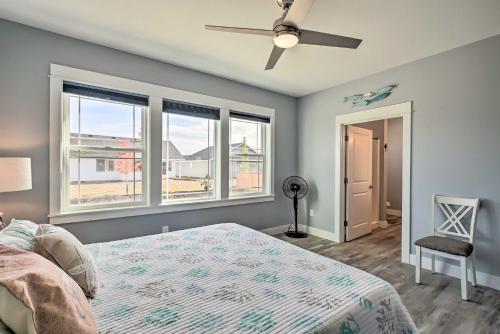 a bedroom with a bed and a ceiling fan and windows at Ocean Shores Getaway with Fireplace and Hot Tub! in Ocean Shores