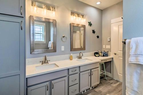 a bathroom with two sinks and two mirrors at Ocean Shores Getaway with Fireplace and Hot Tub! in Ocean Shores