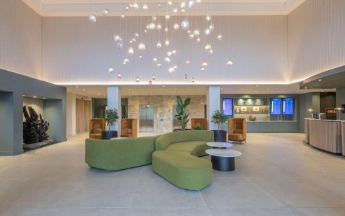 فندق راديسون بلو مطار دبلن في كلوغران: غرفة معيشة مع أريكة خضراء وطاولة