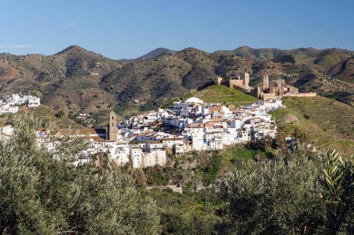 a village on a hill with mountains in the background at Alojamiento Alcantara in Alora