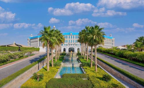 開羅的住宿－開羅凱賓斯基禦美心皇宮酒店，一座在道路前方有棕榈树的建筑