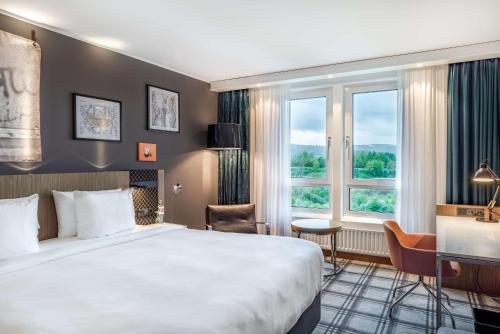 a hotel room with a bed and a window at Radisson Blu Hotel Karlsruhe in Ettlingen