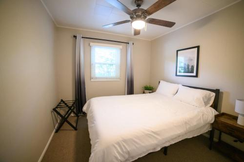 a bedroom with a white bed and a ceiling fan at Adorable and Cozy Bungalow in Great Falls
