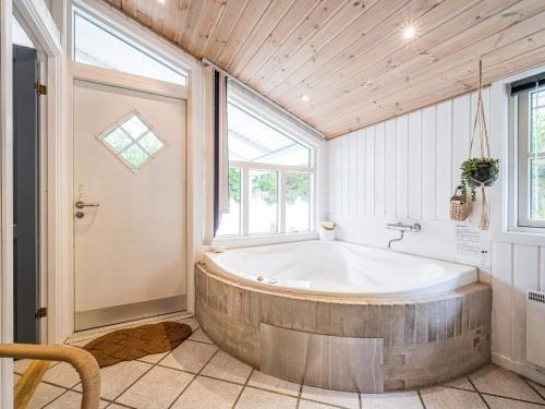 La salle de bains est pourvue d'une baignoire et d'une fenêtre. dans l'établissement Holiday home Nørre Nebel LV, à Nørre Nebel