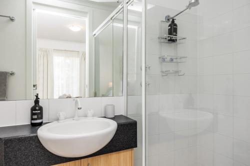 a white bathroom with a sink and a shower at Hurtle Views in Adelaide