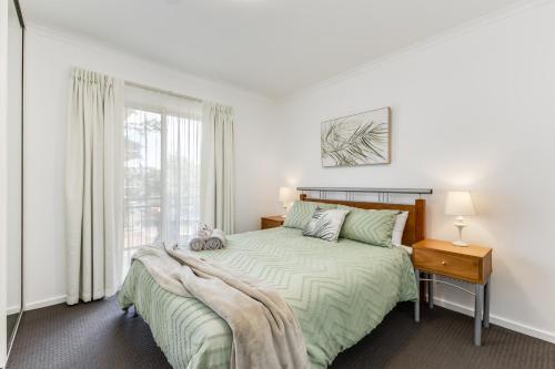 a white bedroom with a bed and a window at Hurtle Views in Adelaide