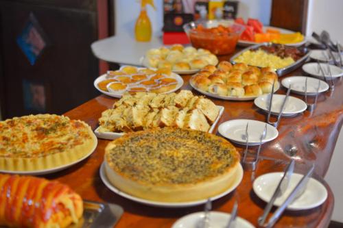 a table with many different types of food on plates at Pousada da praça in Morro de São Paulo