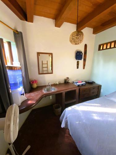 a bathroom with a sink and a bed in a room at Troncones Point Hostel in Troncones
