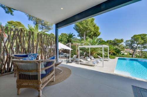 an outdoor patio with a pool and chairs and a swimming pool at Buenavista by Almarina Villas in Benissa