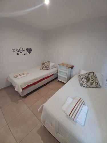 1 dormitorio con 2 camas y mesita de noche en APART OTERO en Ushuaia