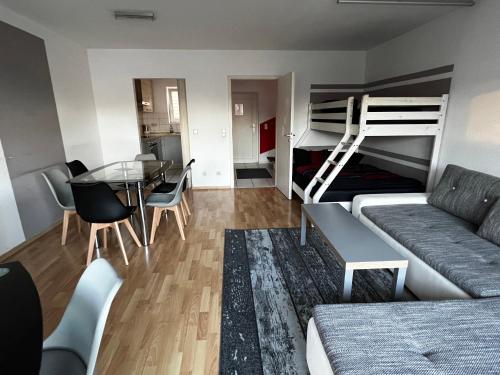 ein Wohnzimmer mit einem Sofa, einem Tisch und einem Etagenbett in der Unterkunft Ferienwohnung Michelle klimatisiert Alemannenstr 1 in 77977 Rust in Rust