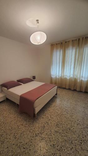 una camera con un grande letto e un lampadario a braccio di Appartement Spacieux Proche Mer a Antibes