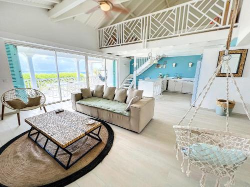a living room with a couch and a swing at Princess Anouk Beachfront Orient Bay Deluxe 3 BDR in Orient Bay