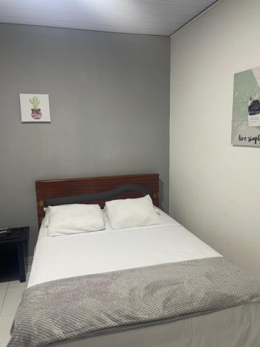 - une chambre avec un grand lit et des draps blancs dans l'établissement Hotel Estadio Exprés, à Leticia