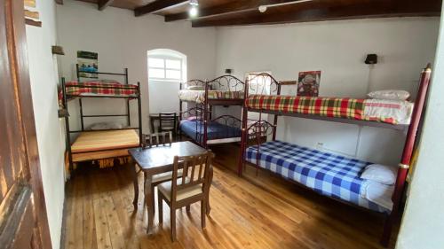 基多的住宿－Hostal La Guayunga RoofTop，客房设有四张双层床和一张桌子及椅子。