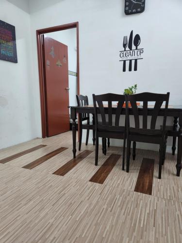 a dining room with a table and chairs and a door at homestay seaview ainee - Muslim sahaja in Kuala Terengganu