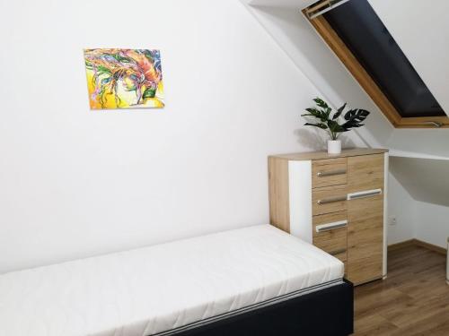a room with a white bench and a wooden dresser at Apartament Marzenie 4 - Opole in Opole