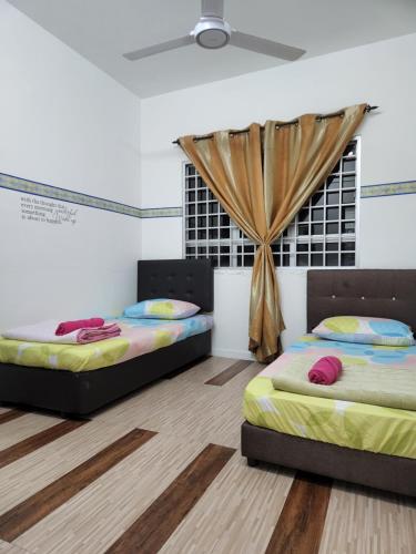 two beds in a room with a window at homestay seaview ainee - Muslim sahaja in Kuala Terengganu