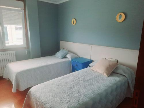 two beds in a room with blue walls at Casa Manola in Teo