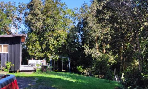 a yard with a goal in the grass with trees at Acogedora cabaña en el bosque, acceso vehiculos 4x4 in Cochamó