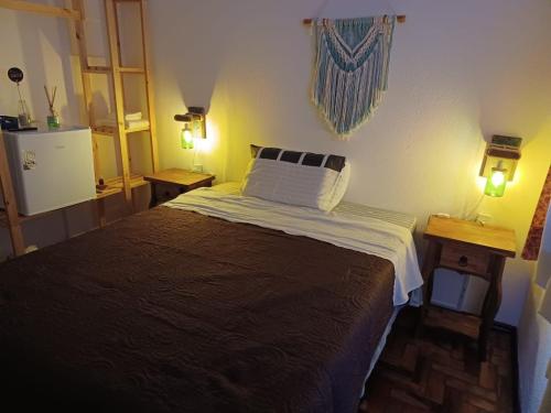 Hospedaria Porto 27 في بورتو بيلو: غرفة نوم بسرير كبير مع مواقف ليلتين