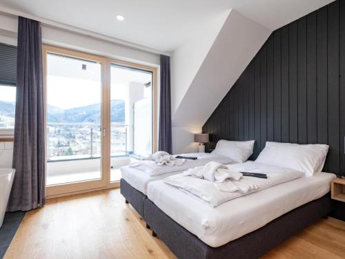 a bedroom with two beds and a large window at Doppellodge in Sankt Lorenzen ob Murau