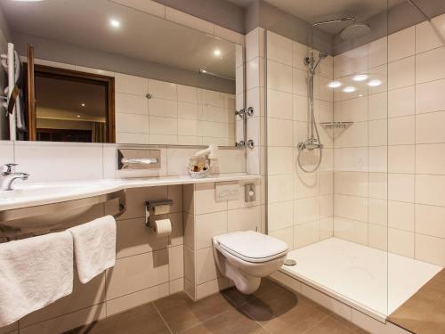 a bathroom with a toilet and a sink and a shower at Romantik Hotel zur Sonne in Badenweiler