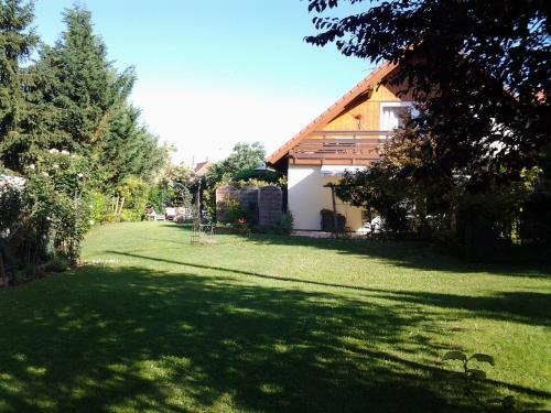 a house in a yard with a large grass field at Les 3 Clés in Dossenheim-Kochersberg
