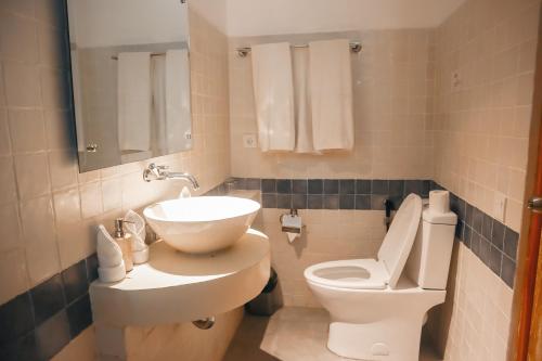 a bathroom with a sink and a toilet at Harbour Komodo Hotel in Labuan Bajo