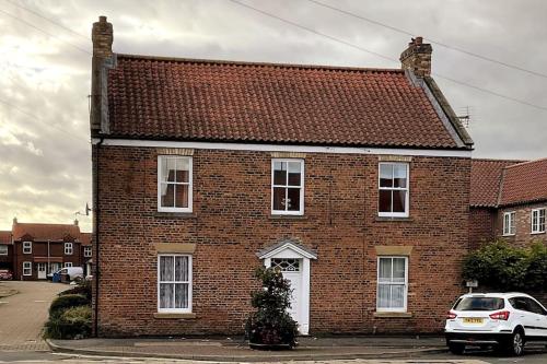 a brick house with a christmas tree in front of it at Apt D in Old Grade 2 Converted Farmhouse in Market Weighton