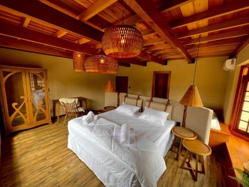 WoodStone Hotel Fazenda في غرامادو: غرفة نوم بسرير وطاولة وكراسي