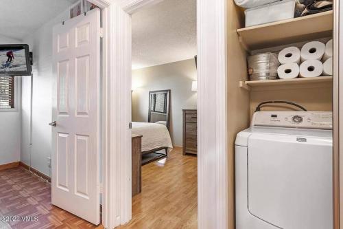 a laundry room with a washer and dryer and a bedroom at Beaver Creek 2 Bed 2 Bath Condo 1 MIN Walk to Elk Lot in Avon