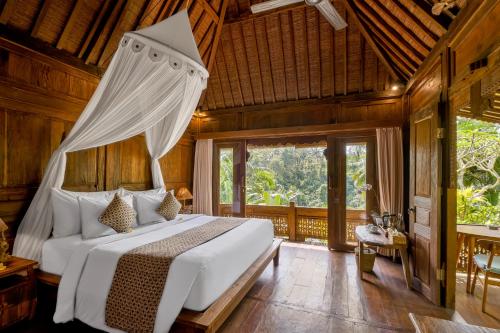 a bedroom with a bed with a canopy at Mandana Ubud Villa in Ubud