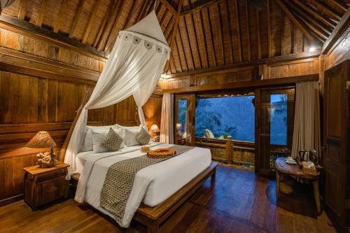 - une chambre avec un lit dans une pièce dotée de murs en bois dans l'établissement Mandana Ubud Villa, à Ubud