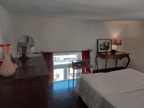 1 dormitorio con 1 cama, ventilador y ventana en Relais del mar- luxury penthouse with terrace, en Nápoles