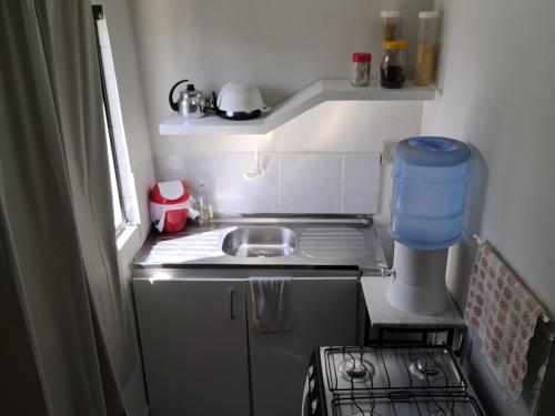 a small kitchen with a sink and a stove at Flat Centro Rota Cachoeira in Bonito