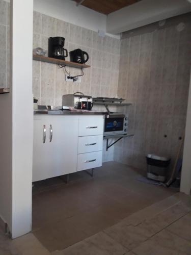 a kitchen with a white counter and a stove at Departamentos Paisaje del Beagle in Ushuaia