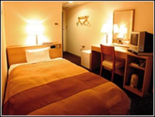 a hotel room with a bed and a desk at Hirosaki Plaza Hotel in Hirosaki