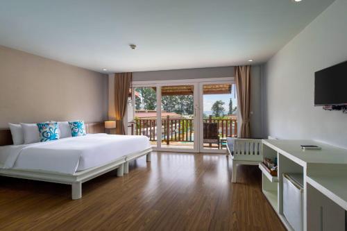 a bedroom with a large bed and a balcony at Arinara Beach Resort Phuket - SHA Extra Plus in Bang Tao Beach