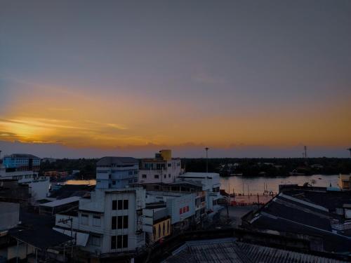 a view of a city with the sunset in the background at The Harbour Front Hotel in Suratthani