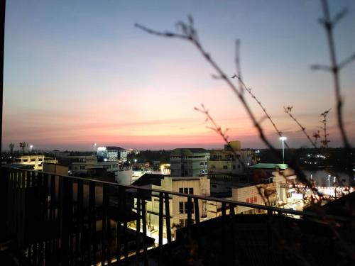 a view of a city at sunset from a balcony at The Harbour Front Hotel in Suratthani
